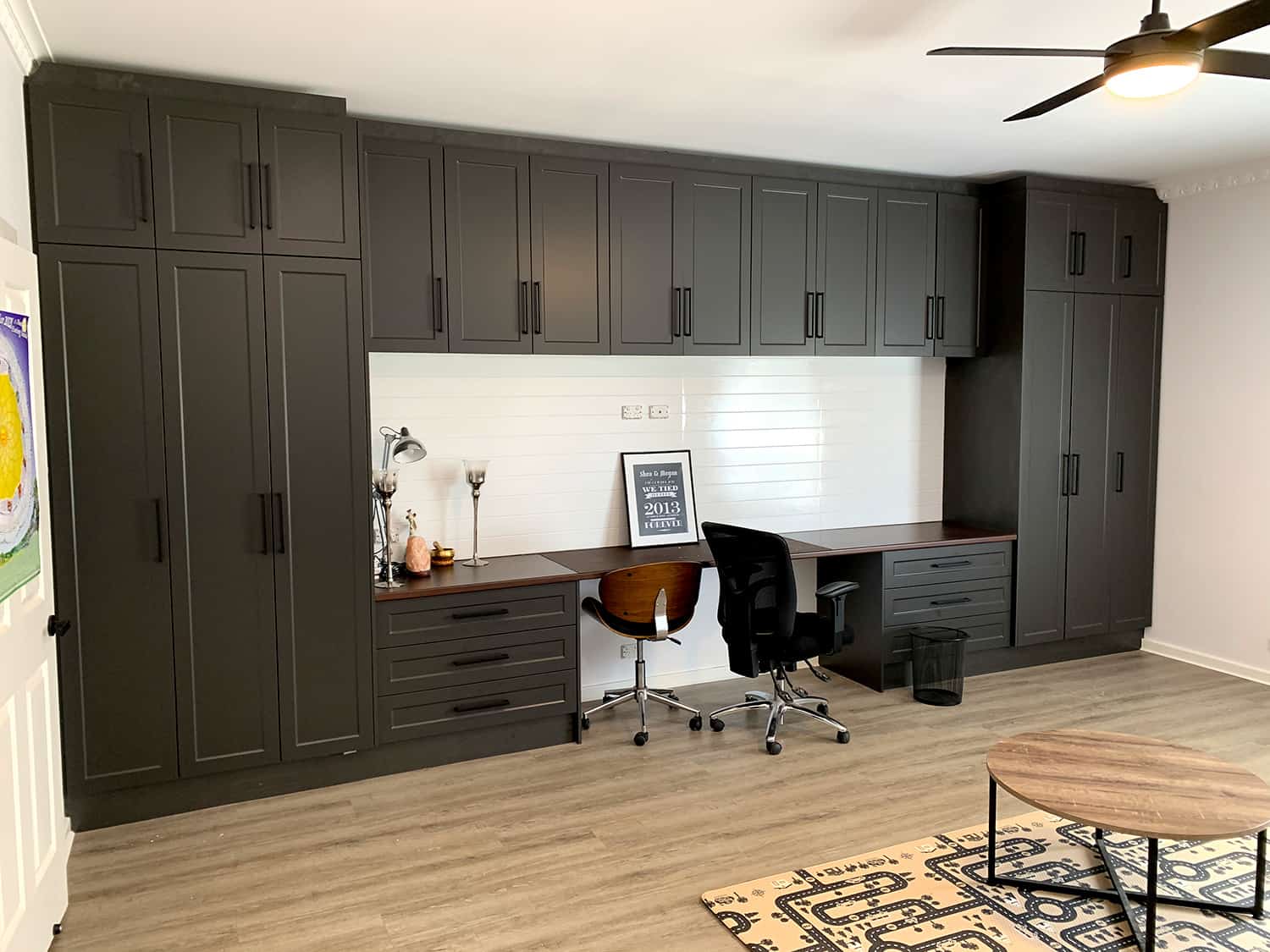 Custom charcoal built-in storage wall with an integrated home-office desk