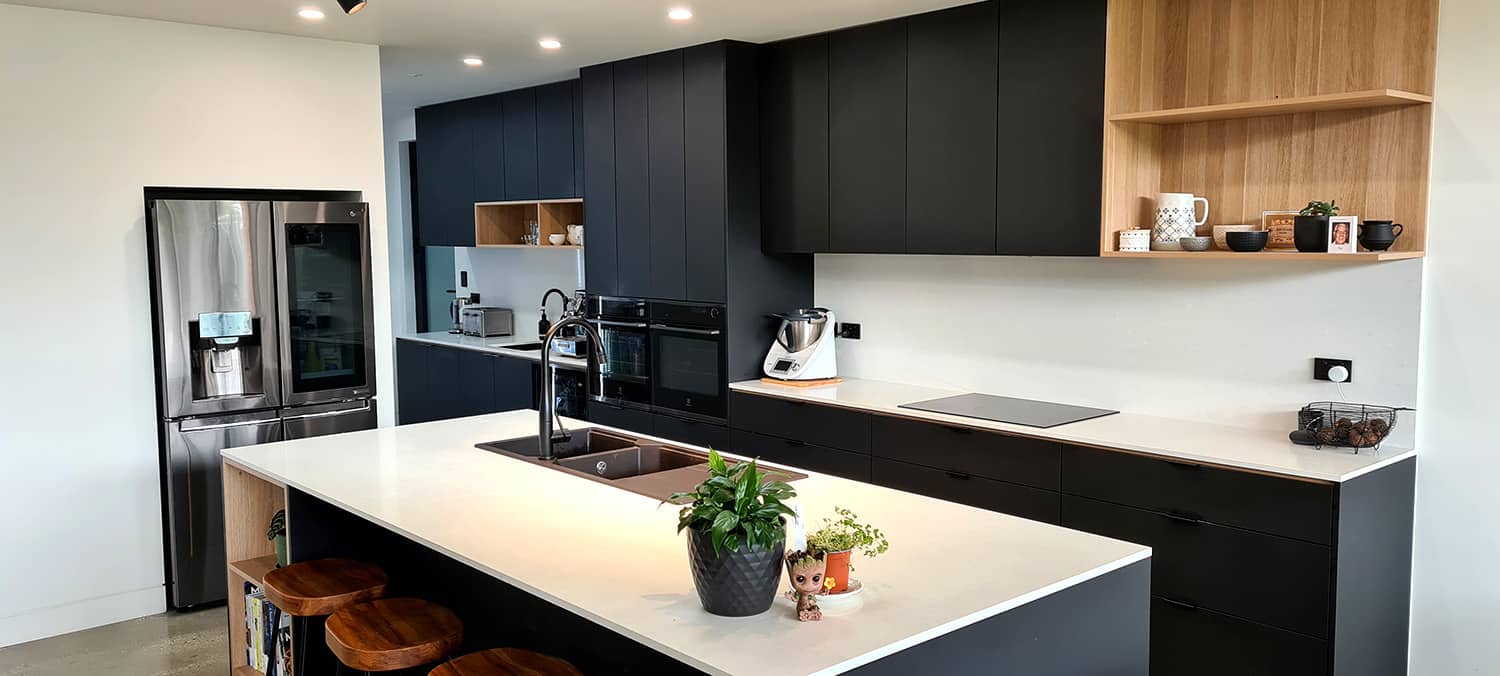 Modern matte-black kitchen with a white stone island and warm oak shelving